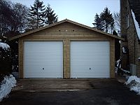 Double Shiplap Clad Garage with a pair of White Metal Up & Over Doors